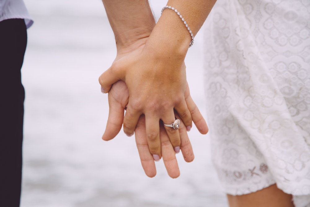 married couple wearing colored diamond wedding rings
