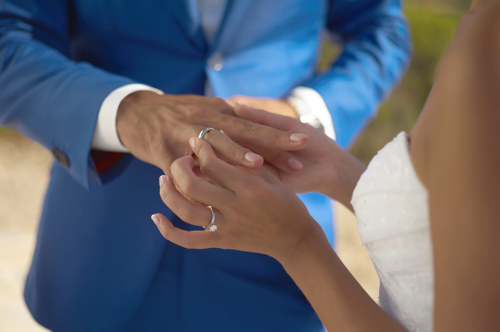 A woman sliding on her husband's wedding ring