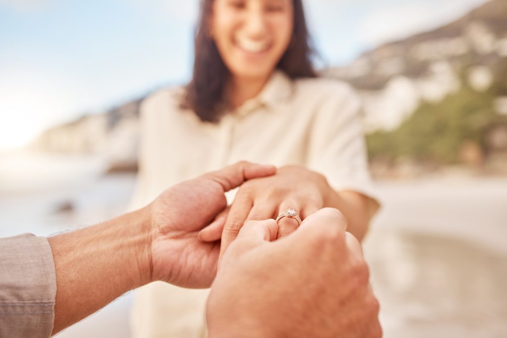 A woman on the beach wearing her engagement ring