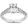 A silver engagement ring features a large central diamond surrounded by smaller stones along the band.