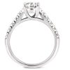 A silver ring features a prominent diamond set in a polished band with smaller stones adorning the side.