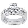 A silver engagement ring with a central round diamond and smaller diamonds set in a curved band.