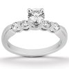 A silver ring with a central round diamond and four smaller diamonds set on the band.