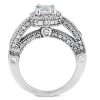 A silver ring with a large rectangular center stone and multiple smaller diamonds set in an intricate band design.