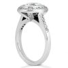 A silver ring with a round diamond centerpiece surrounded by smaller diamonds, viewed from the side.