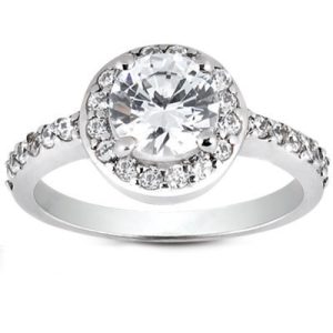 A silver engagement ring features a large round diamond at the center, surrounded by smaller diamonds along the band.