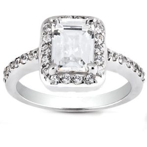 A silver ring features a prominent rectangular diamond surrounded by smaller stones on its band.