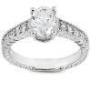 A silver ring with an oval diamond center stone and smaller diamonds set along the band.