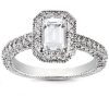A silver ring with an emerald-cut diamond centerpiece and a pavé setting is displayed.