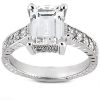 An emerald-cut diamond ring with a silver band and smaller diamonds set along the sides.