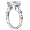 A silver ring featuring a large, clear gemstone in a raised setting surrounded by smaller stones along the band.