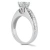 A silver engagement ring features a large diamond setting with intricate band detailing.
