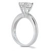 A silver engagement ring with a large round diamond is displayed upright, showcasing its elegant setting.