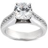 A silver engagement ring features a large round center stone with smaller stones set along the band.