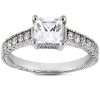 A silver engagement ring features a large square diamond surrounded by smaller sparkling stones on the band.