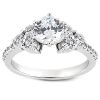 A silver engagement ring features a large round center diamond surrounded by smaller stones along the band.