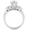 A silver ring features a large central diamond surrounded by smaller diamonds on either side.