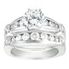 A white gold engagement ring set with a large round diamond centerpiece and smaller diamonds in a channel setting.