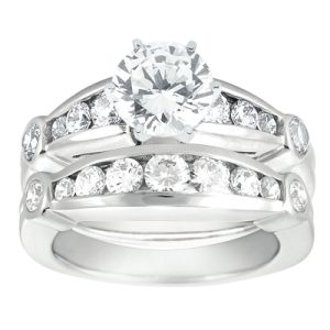 A white gold engagement ring set with a large round diamond centerpiece and smaller diamonds in a channel setting.