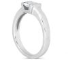 A silver ring with a large, clear diamond set in a raised position.