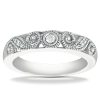 A silver ring featuring intricate swirling patterns and a central diamond.