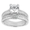 A silver engagement ring set features a large central gemstone surrounded by smaller stones on a multi-band design.