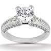 A shiny silver engagement ring features a large round diamond at the center, surrounded by smaller diamonds along the band.