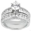 A silver ring set featuring a large central round stone surrounded by smaller stones along the band.