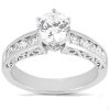 A silver ring with a large round diamond in the center and smaller diamonds set along the band.