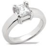 A silver engagement ring features a large, square-cut clear gemstone at its center.