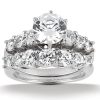 A diamond engagement ring set features a central round-cut diamond surrounded by smaller round diamonds on a white metal band.