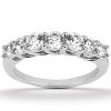 A silver ring features a row of six round, clear gemstones set in a prong setting.