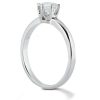 A silver engagement ring with a prominent diamond set in a four-prong setting is displayed against a plain background.