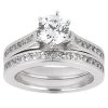 A silver engagement ring with a large round diamond in a center setting and smaller diamonds embedded along the band.