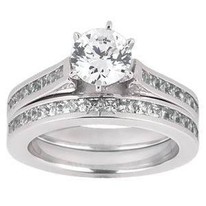 A silver engagement ring with a large round diamond in a center setting and smaller diamonds embedded along the band.