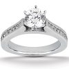 A silver engagement ring features a large round diamond at the center with smaller stones along the band.