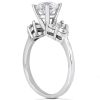 A white gold engagement ring features a large central diamond surrounded by smaller diamonds.