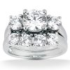 A polished silver ring features a large central diamond surrounded by five smaller diamonds.