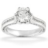 A silver engagement ring with a large round diamond centerpiece and smaller diamonds set along the band.