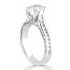 A silver engagement ring featuring a prominent round diamond at the center and smaller accent diamonds along the band.