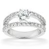 A silver ring features a large round diamond in the center, flanked by smaller diamonds along the band.