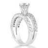 A silver engagement ring set featuring a large diamond on a detailed band with smaller stones.