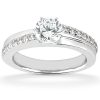 A silver engagement ring with a round central diamond and smaller diamonds set along the band.
