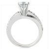 A silver engagement ring features a large, clear diamond set in a raised position, with smaller diamonds adorning the band.