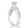 A silver engagement ring with a prominent diamond and smaller stones along one side.