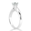 A silver engagement ring features a prominent round-cut diamond set in a four-prong setting.