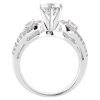 A silver engagement ring with a central diamond and two smaller diamonds on each side is displayed from above.