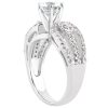 A silver ring features a large diamond at the center, flanked by smaller diamonds along the band.
