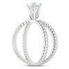 A silver ring features a diamond accent with two intertwined loop designs.