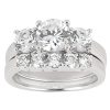 A silver ring featuring a cluster of three large round diamonds and a row of smaller diamonds along the band.